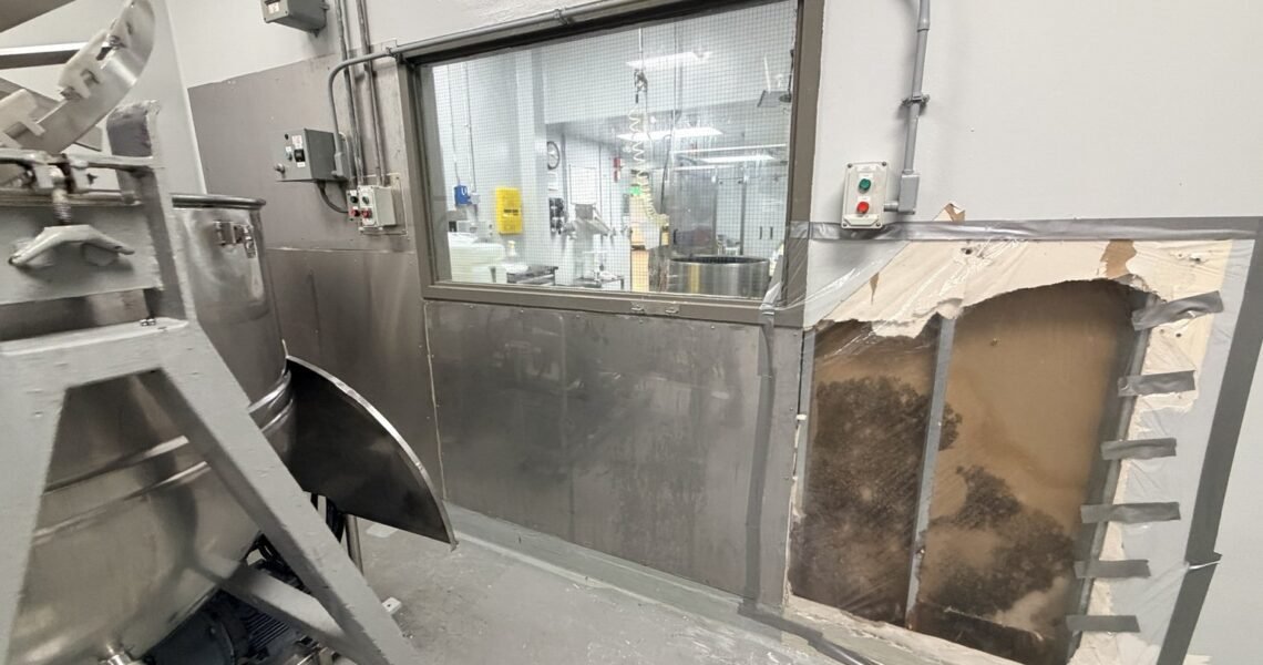 Concealed wall damage beside protected manufacturing equipment
