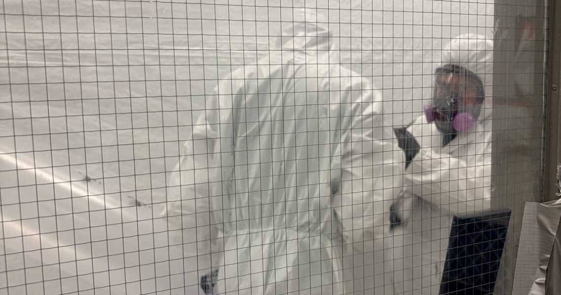 Remediation technicians wearing respirators and protective coveralls